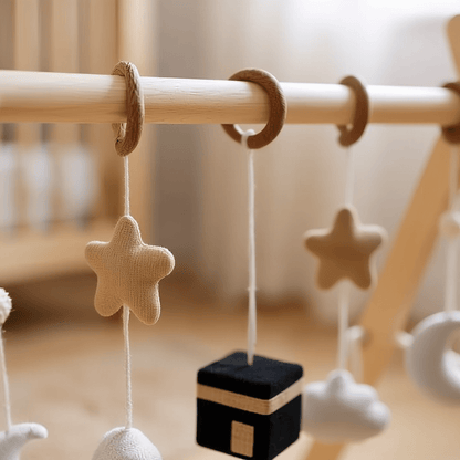 Wooden baby play arch with hanging toys and Islamic symbols, from birth